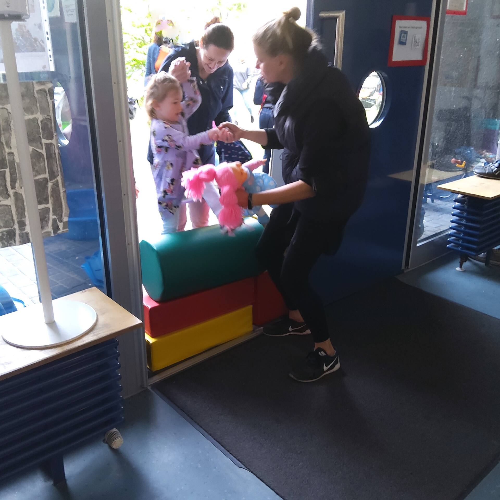 mehrere Kinder und eine Frau stehen in einer Tür gegenüber 