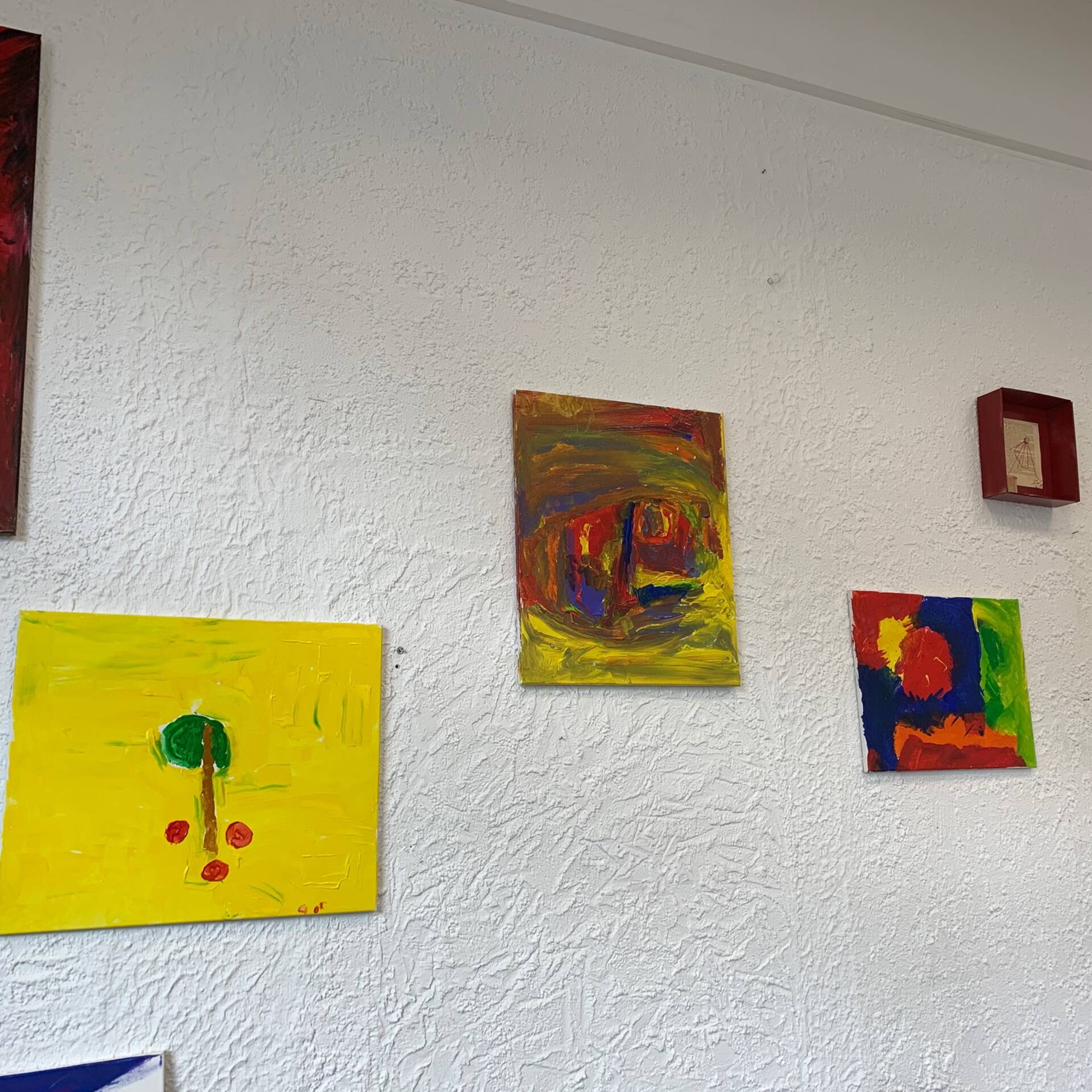 Bilder hängen an einer weißen Wand.