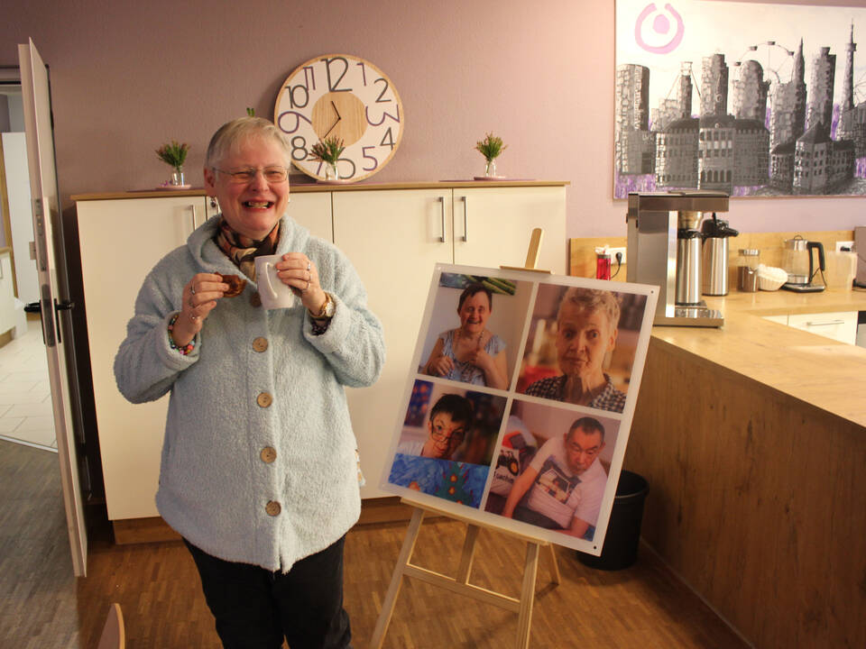 Eine Frau steht neben einer Fotocollage
