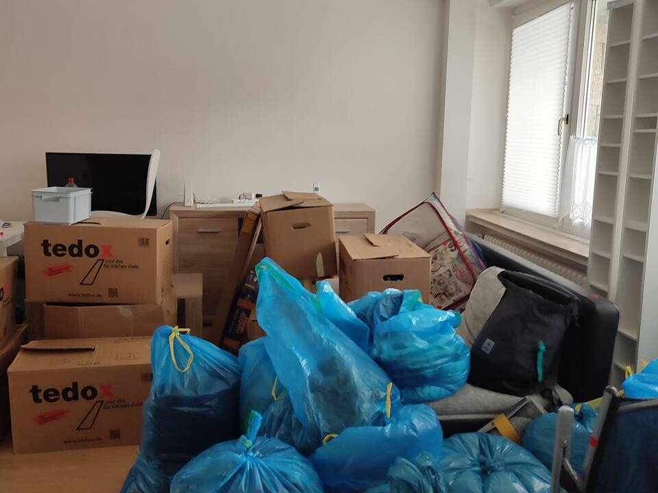 In einem Raum stehen viele Kartons und Tüten.