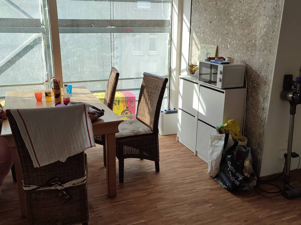 Stühle, Schränke und Tüten in einem Raum.