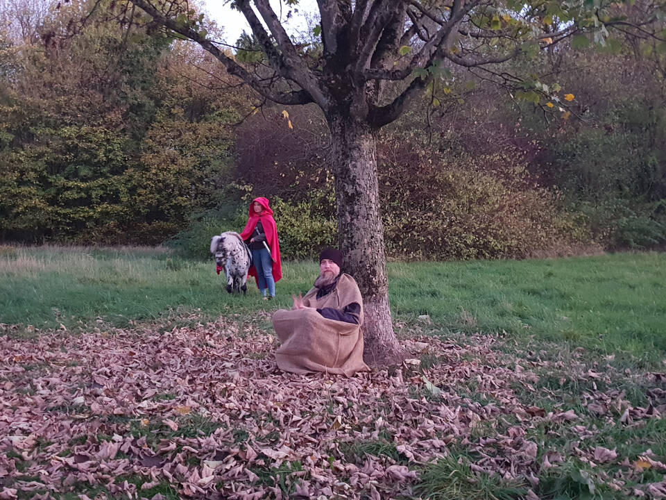 St. Martin kommt mit einem Pony und ein Bettler sitzt an einem Baum.