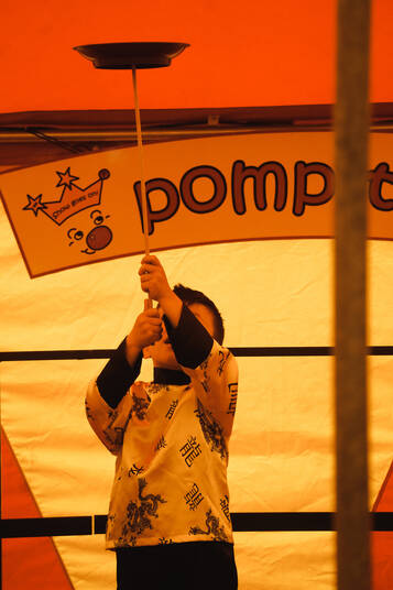 Ein Kind dreht einen Teller auf einem Stock