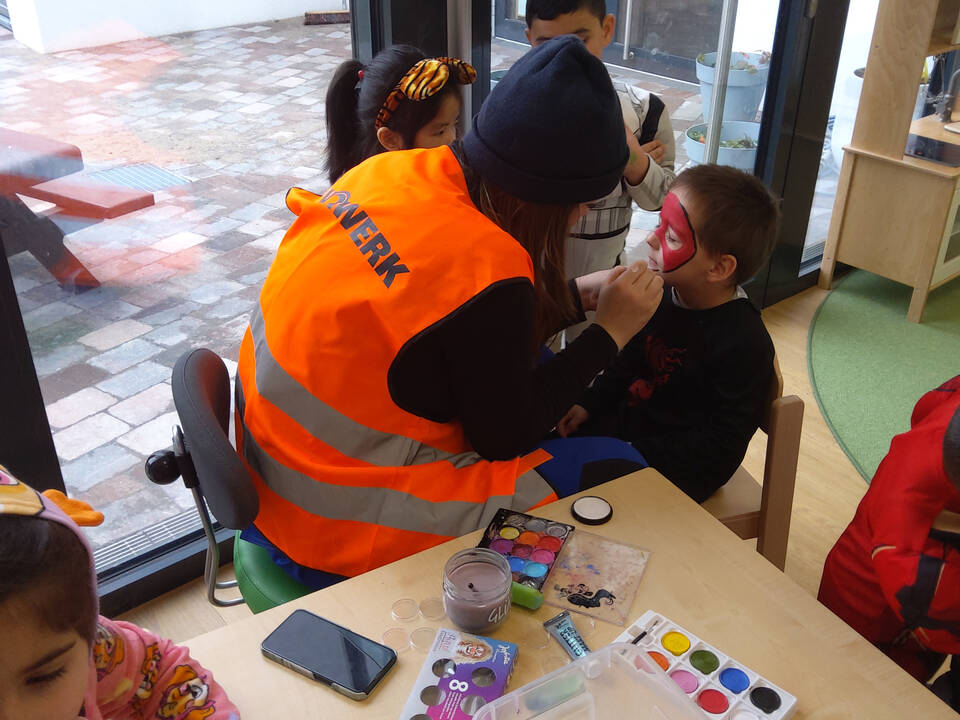 Eine Person schmikt ein Kind.