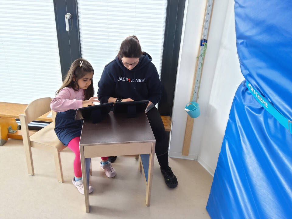 Zwewi Personen sitzen vor Tablets