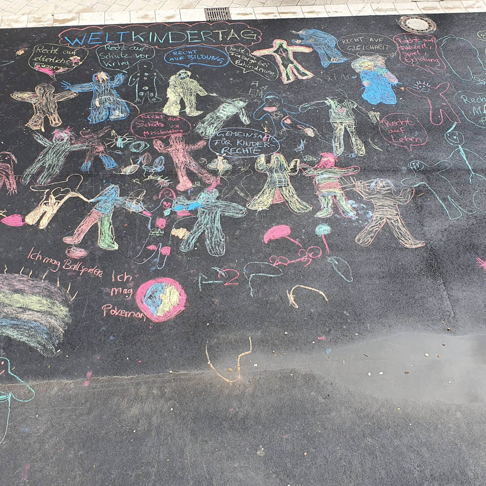 Figuren mit Kreide auf Straße gemalt.