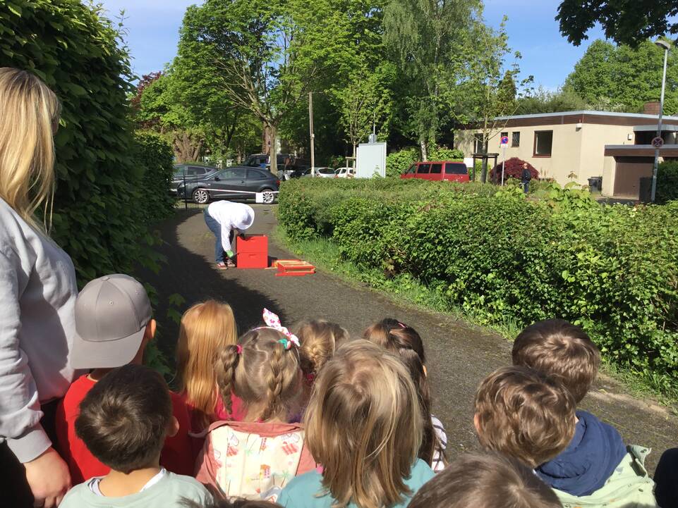 Der Imker packt zusammen und Kinder schauen zu.