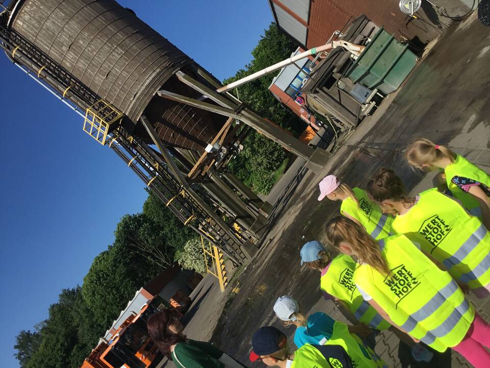 Kinder stehen vor einem großen Silo.