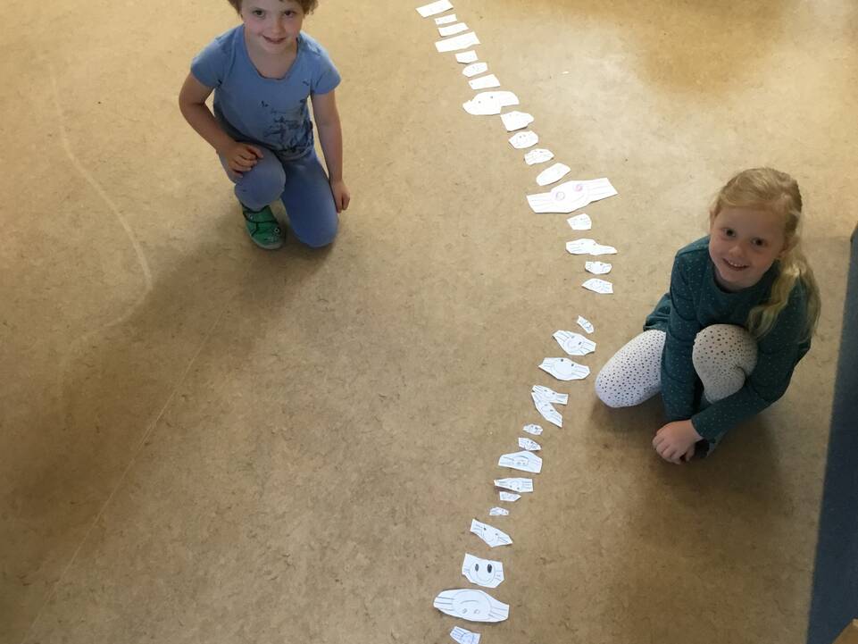 Zwei Kinder neben einem Papierweg.