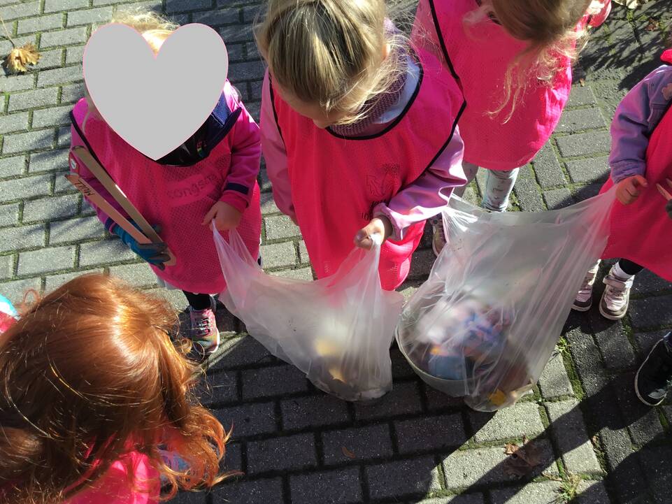 Kinder mit Mülltüten in der Hand.