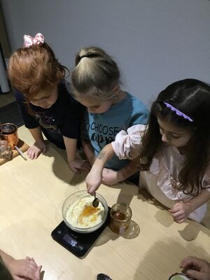 Kinder wiegen Honig ein.