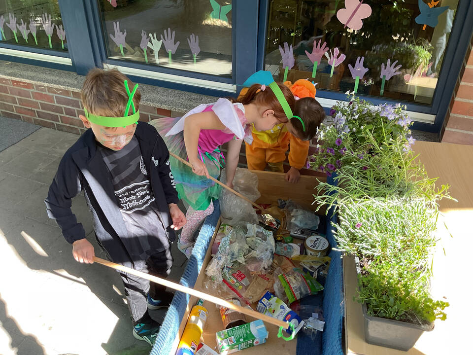 Zwei Kinder angeln Müll.