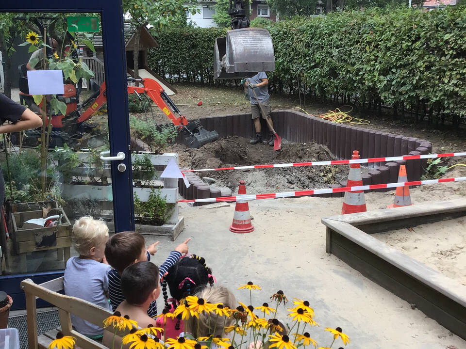 Kinder schauen zwei Baggern zu.