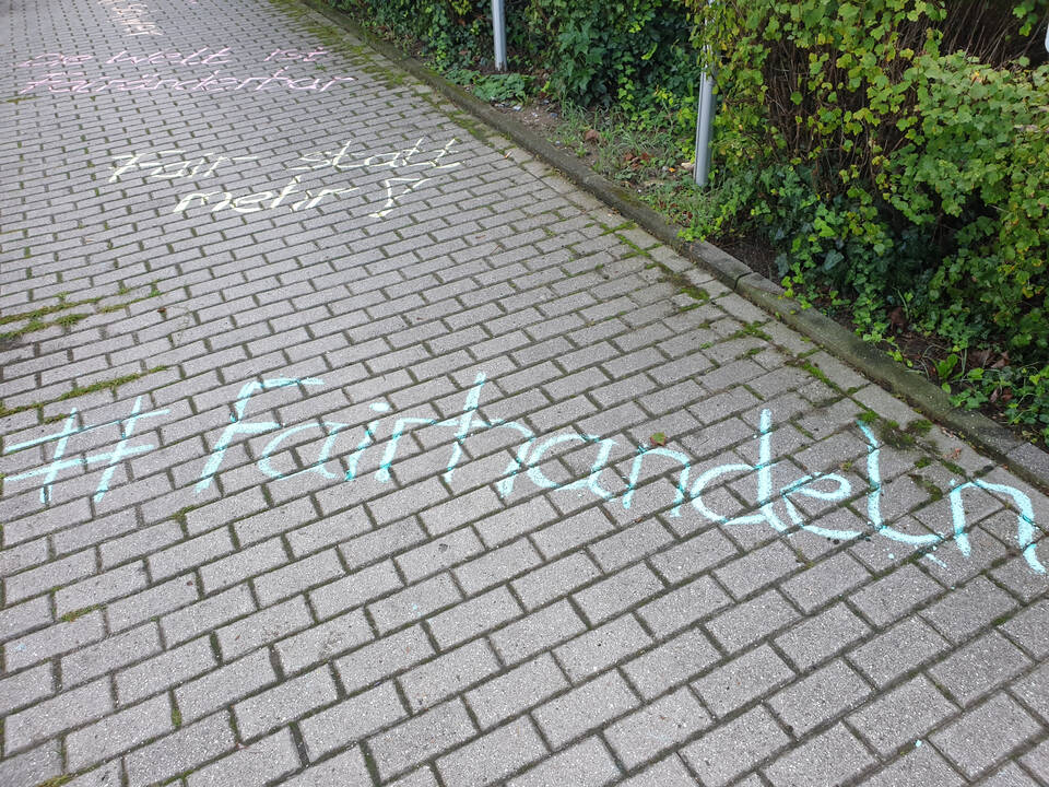 Auf Steinen steht mit Kreide die Welt ist Fairänderbar