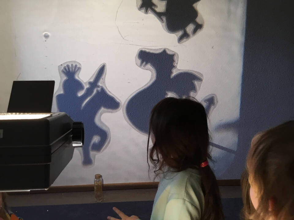 Kinder schauen auf eine Wand mit Schatten