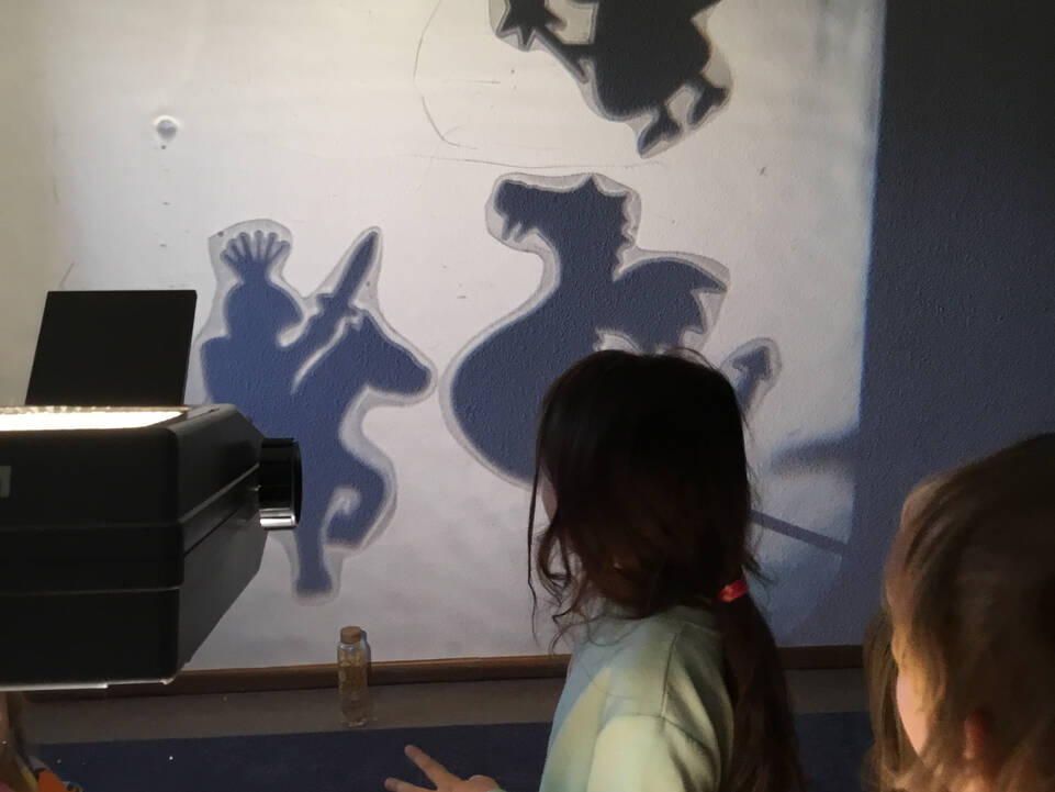 Kinder schauen auf eine Wand mit Schatten