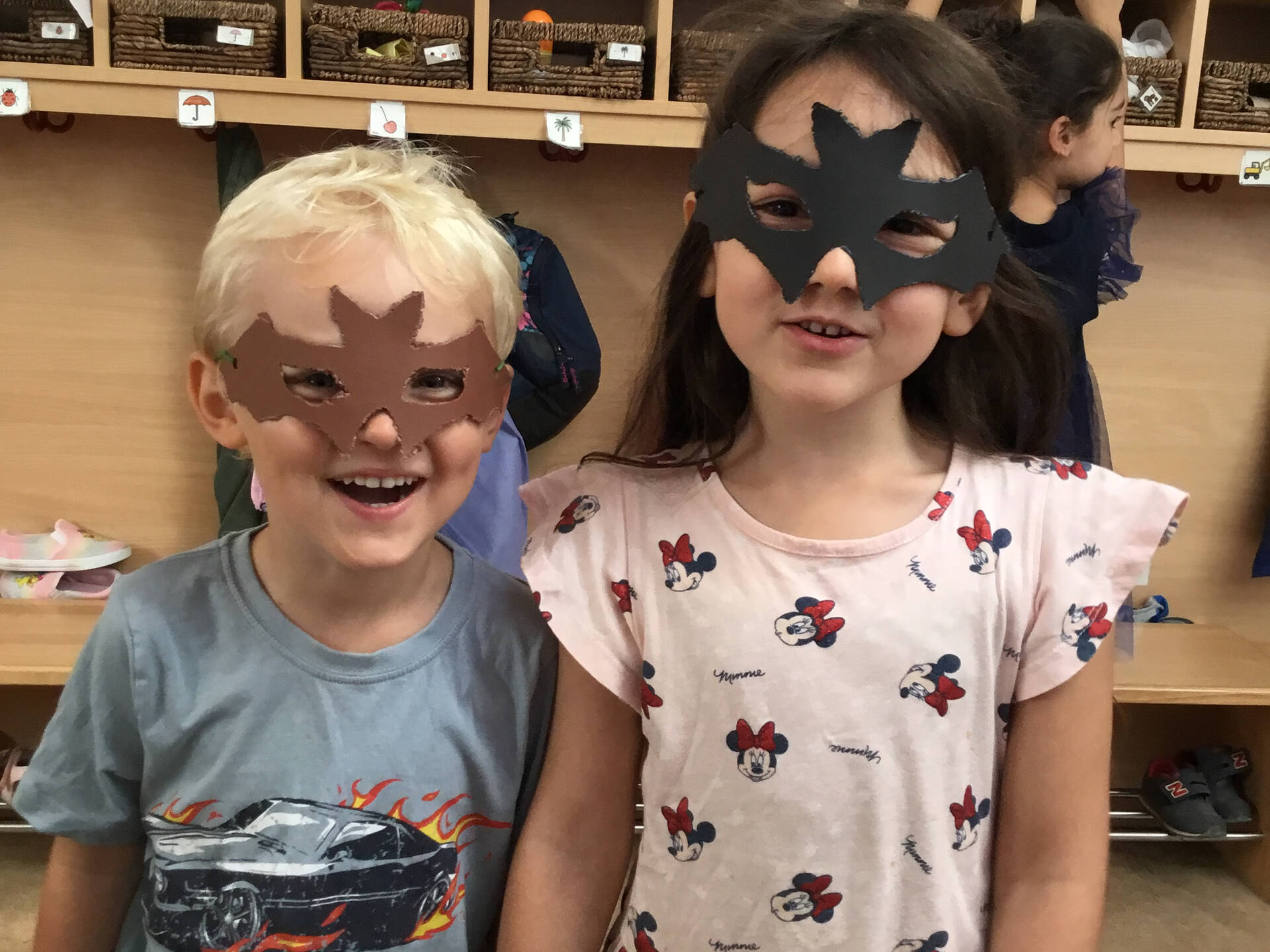 Zwei Kinder mit Fledermausmasken im Gesicht.