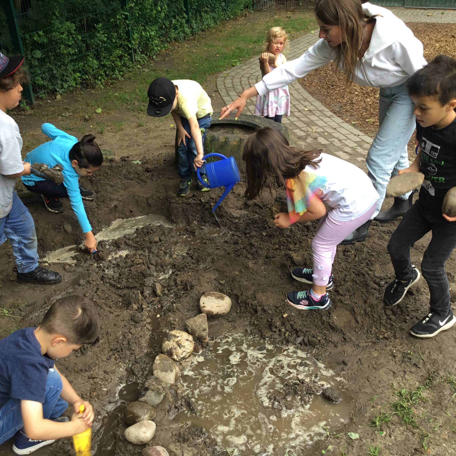Kinder spielen und graben im Matsch.