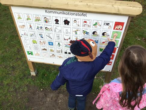 Kind an Kommunikationstafel