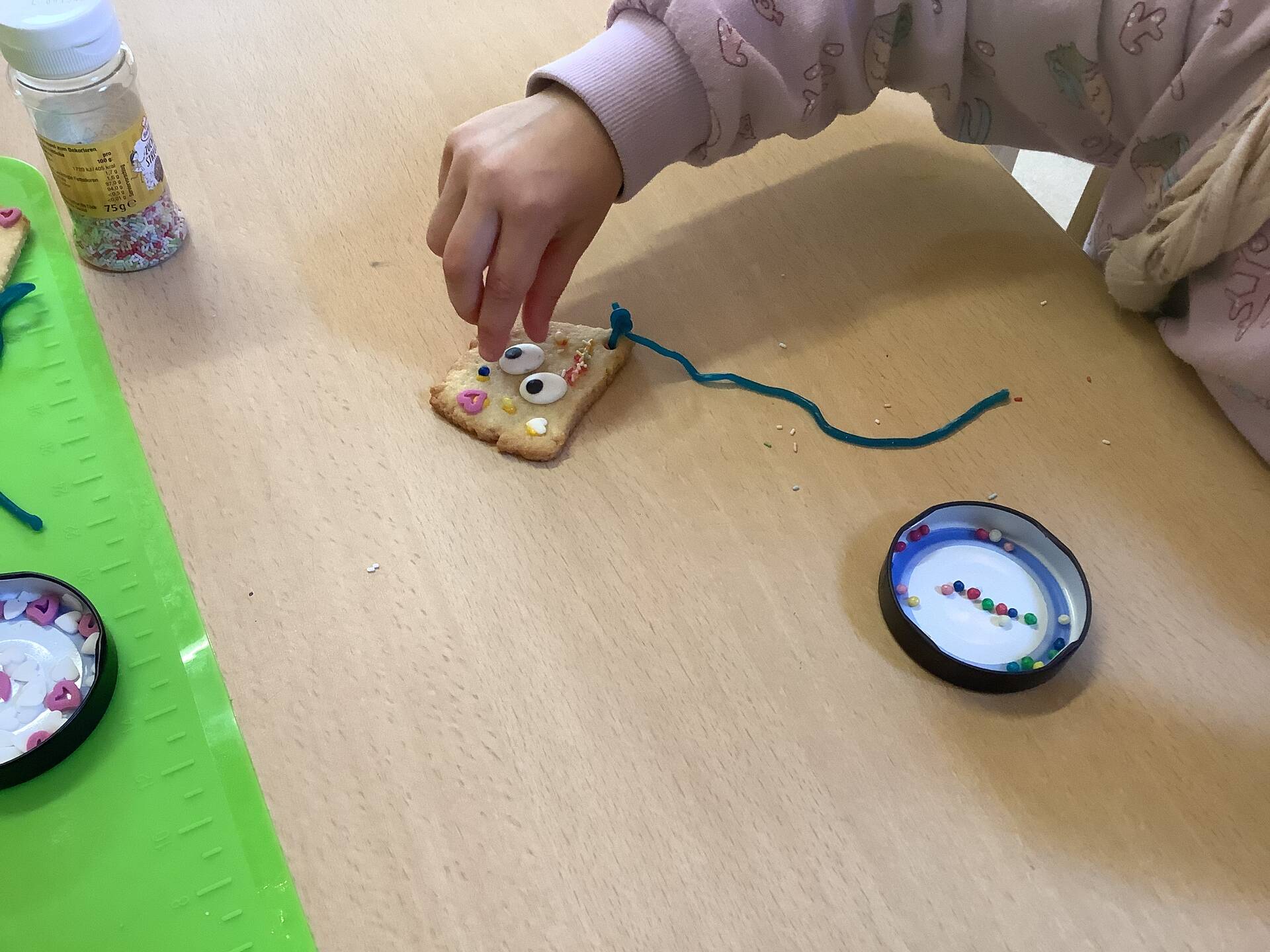 Eine Hand verziert ein Plätzchen