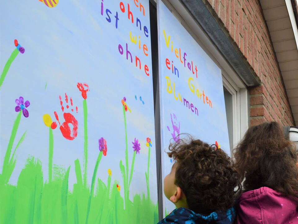 Zwei Kinder vor dem großen Fenster