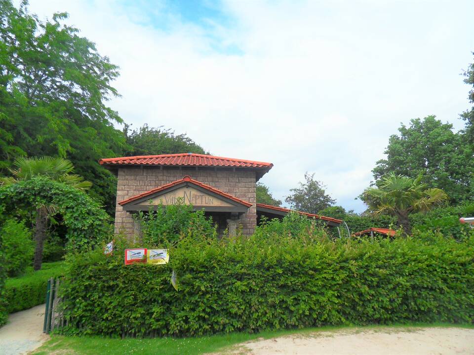 Ein kleines Gebäude hinter einer Hecke.