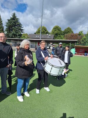 Zuschauer, eine Frau hat eine große Trommel.