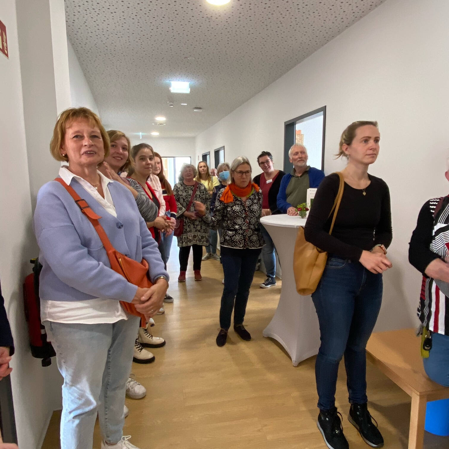 Vielke Personen stehen in einem Flur.