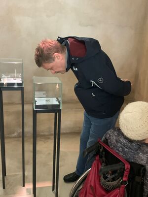 Ein Mann schaut sich etwas in einem Austellungskasten an.