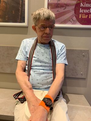 Ein  Mann sitzt auf einer Bank.