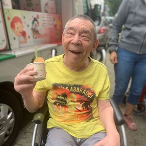 Ein Mann im Rollstuhl mit einem Eisbecher.