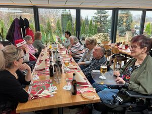 Gruppenfoto am gedeckten Tisch.