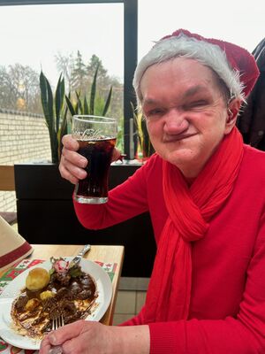 EIne Person mit Nikolausmütze und Cola schaut in die Kamera