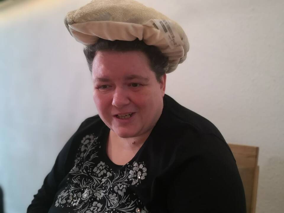 Eine Frau mit einem hellen Kissen auf dem Kopf.