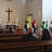 Einiige Personen sitzen in den Bänken einer Kirche.