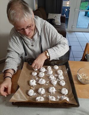 Eine Frau drückt kuhlen in die Plätzchen.