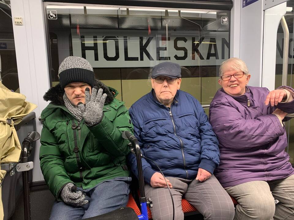 Drei Personen sitzen in einer Bahn