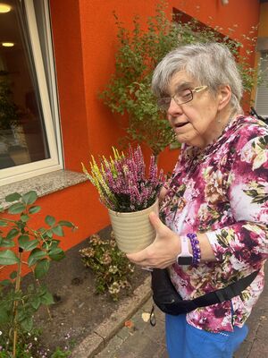 Eine Frau mit einer Herbstpflanze in der Hand.