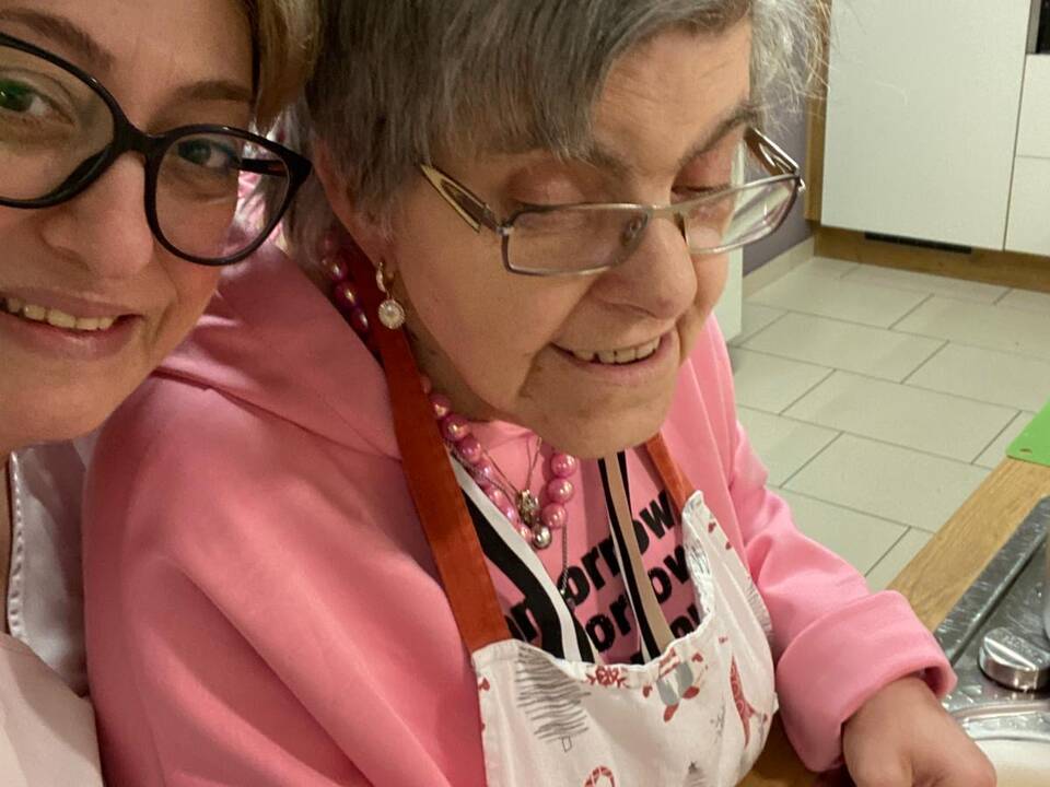 Zwei Frauen lachen beim Kartoffelschhälen.