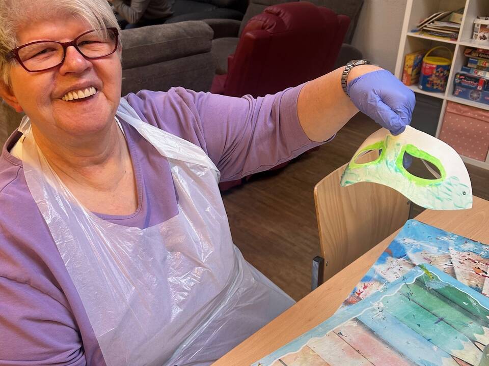 Eine Frau bemalt eine Maske