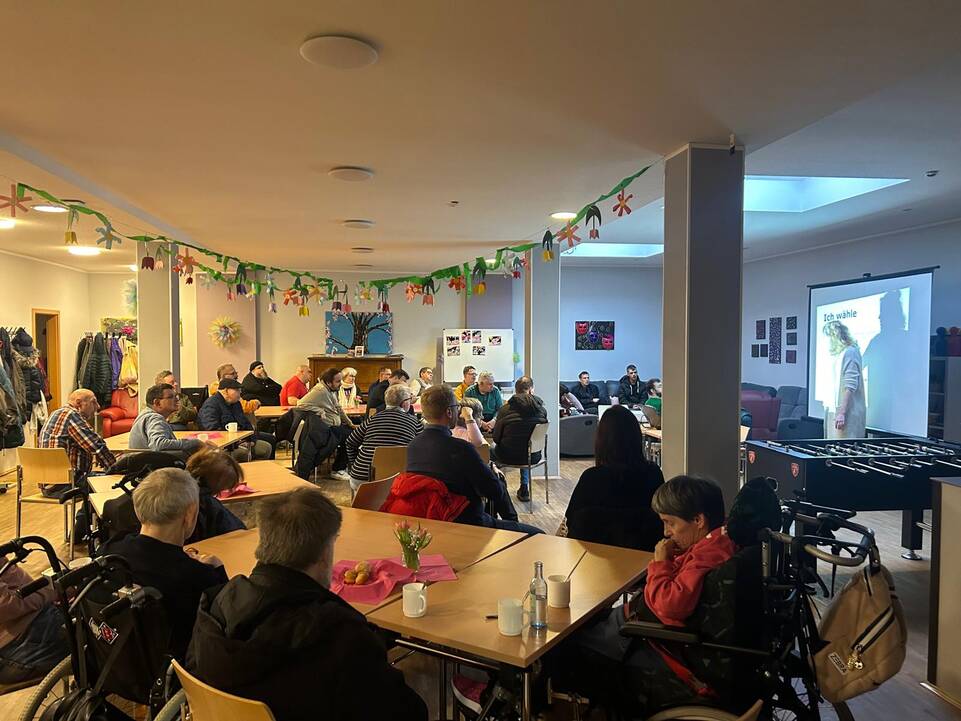 Viele Gäste auf einer Veranstaltung in einem großen Raum.