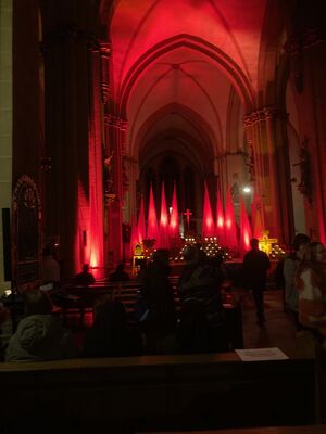 Ein rotbeleuchteter Inenraum einer Kirche.