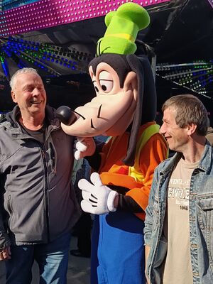 Zwei Personen neben Goofy.