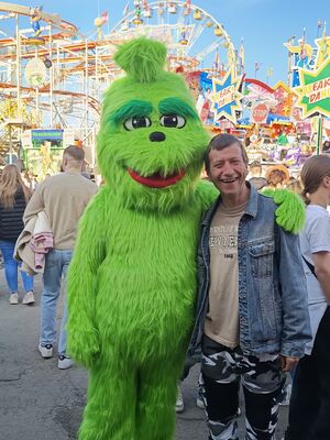 Ein Mann wird vom Grinch in den Arm genommen