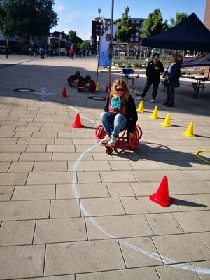 Eine Frau fährt mit einem Fahrzeug zwischen Pilonen durch.