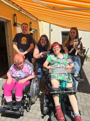 Gruppenfoto mit Bewohnern und einem kleinen Hund.
