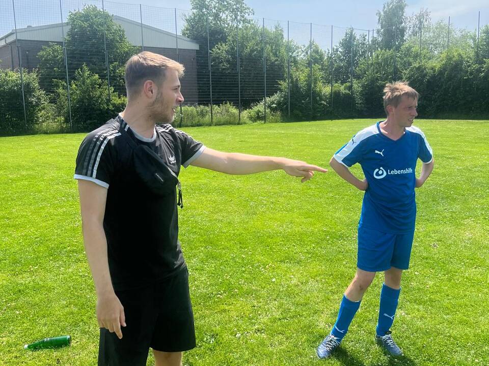 Der Schiedrichter steht neben einem Spieler.