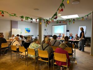 Zuhörer und Politiker in einem großen Raum.