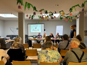 Zuhörer und Politiker in einem großen Raum.