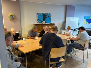 Einige Gäste der Veranstaltung sitzen an einem großen Tisch.
